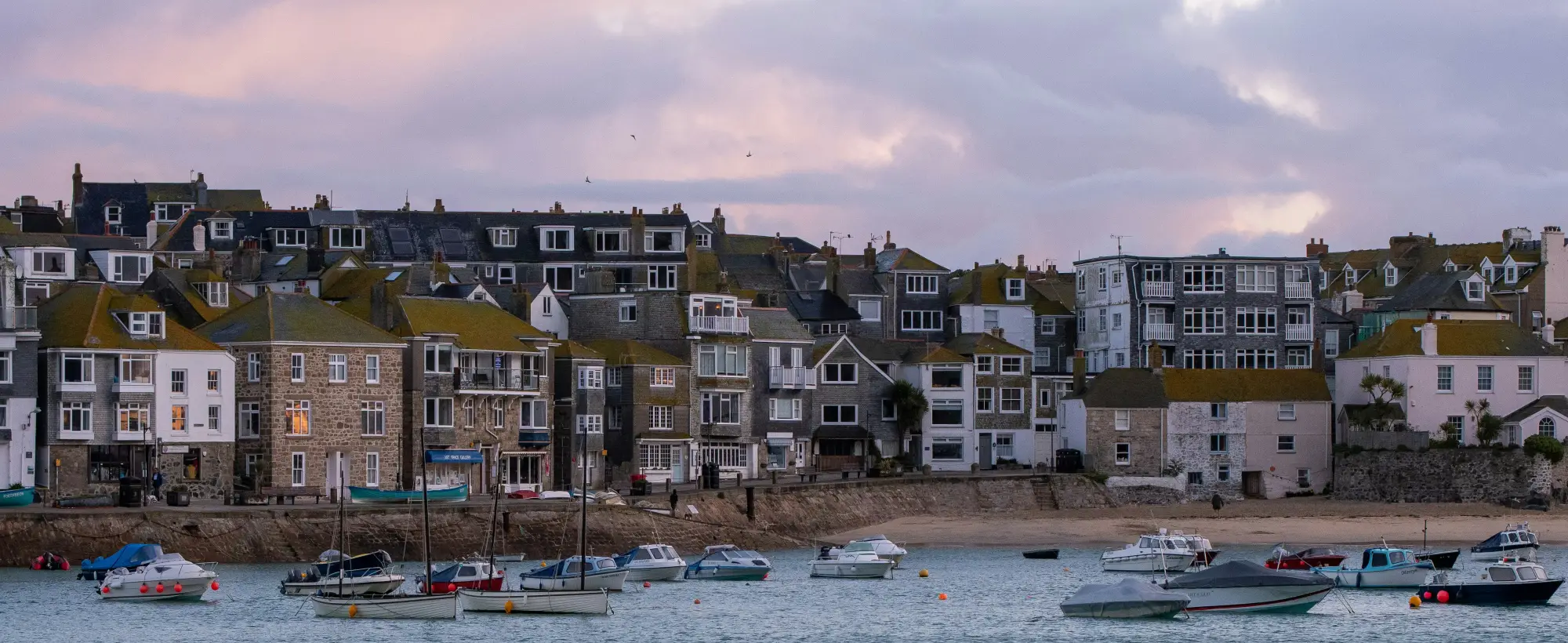St Ives harbour and the old town at dusk, boats moored on the sand